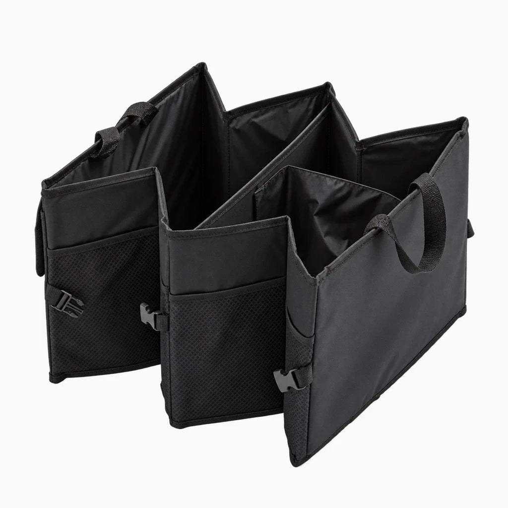 Rangement de coffre de voiture déplié contenant outils et courses organisés